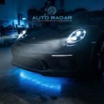 auto esportivo com os faróis de led acesos, dentro de uma oficina