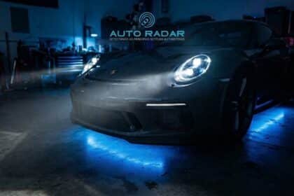 auto esportivo com os faróis de led acesos, dentro de uma oficina